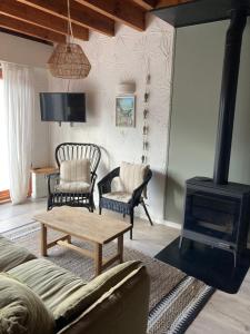 a living room with a couch and a wood stove at Maison calme Quend-Plage Petite Californie in Quend-Plage