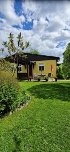 a yellow house with a lawn in front of it at Ferienhaus Rumpelt in Kurort Gohrisch +13 photos