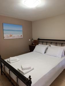 a bedroom with a large white bed with towels on it at Anna's Cozy Home in Argostoli