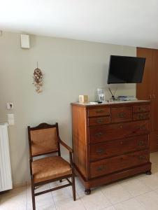 a room with a dresser and a chair and a television at Anna's Cozy Home in Argostoli