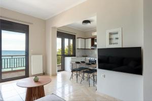 a kitchen and living room with a view of the ocean at Flat on the sea in Poros