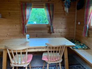 a wooden table and chairs in a room with a window at Haus Ernestine in Sankt Urban