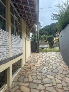 a stone walkway in front of a building with a porch at Casa Quina da mata in Santo Antônio do Pinhal