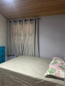 a bed with a window in a bedroom at Casa Quina da mata in Santo Antônio do Pinhal