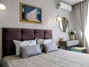 Un dormitorio con una cama grande y un espejo. en Ika Apartment Central, en Burgas 20 fotos más