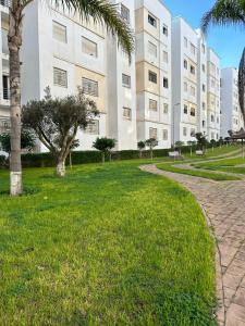 a building with a palm tree and a walkway at Brise de Tamaris in Oulad Akkou