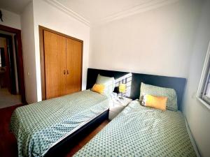 a bedroom with two beds and a wooden door at Brise de Tamaris in Oulad Akkou