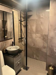 a bathroom with a sink and a glass shower at Chic Compact Apartment in Oulu