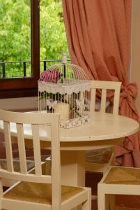 una jaula de aves sentada en una mesa junto a una ventana en Locanda San Barnaba en Scarperia
