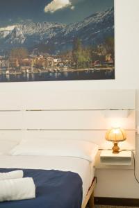 莱科Pizza & Pizzoccheri House的卧室里有一张床，墙上挂着一幅画