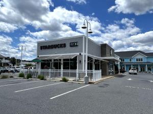 a store in a parking lot next to a street at Renovated OC Condo Walk to Beach Pool & Park in Ocean City