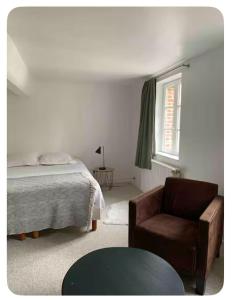 a bedroom with a bed and a couch and a chair at Charmante maison de pêcheur Etretat in Étretat