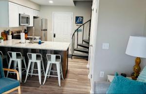 a kitchen with a counter and stools in a room at Renovated OC Condo Walk to Beach Pool & Park in Ocean City +11 photos