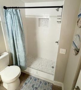 a bathroom with a shower with a toilet and a shower curtain at Renovated OC Condo Walk to Beach Pool & Park in Ocean City