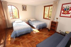 阿雷基帕Condo located just 4 blocks from the main square的一间卧室配有两张床和一张沙发。