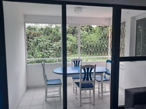 a dining room with a table and chairs and a window at Océanie in Le Lamentin