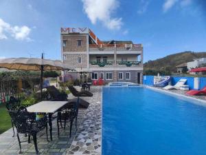 a swimming pool with a table and chairs next to a building at Mountain Cove Villa in Pagudpud