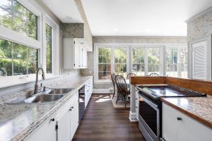 a kitchen with white cabinets and a sink and windows at WestWind Estate in Spartanburg