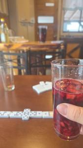 a hand holding a glass of drink on a table at Cabaña acogedora en Shangrilá, Las Trancas, cerca de Termas de Chillán y pistas de ski in Las Trancas
