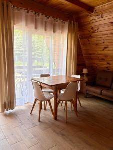 a wooden table and chairs in a room at Domki letniskowe do wynajęcia - Zielony Zakątek in Okuninka