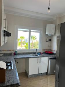 a kitchen with a sink and a window at Apparemment Martil Sofia bay in Martil