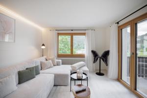 a white living room with a couch and a table at Bergjuwel Aura - Bergkristall in Scuol