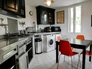 une cuisine avec une table, une cuisinière et un lave-vaisselle dans l'établissement La maison du cerf, à Bergues 6 autres photos