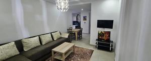 a living room with a couch and a table at Résidences Mansbay Jasmin in Mansouria