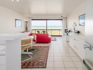a kitchen and living room with a view of the ocean at Grand Hotel D3 G in Oostduinkerke