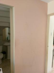 a bathroom with a white wall and a toilet at EcuaRent in SamborondÃ³n
