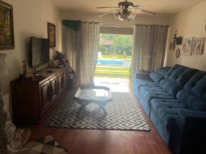 a living room with a blue couch and a television at Suíte do Morro in Pomerode