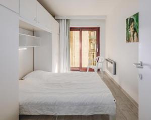 a white bedroom with a bed and a window at Grand Hotel D3 G in Oostduinkerke +18 photos