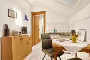 a small kitchen with a table and a chair at Pension Anna in Bodenmais