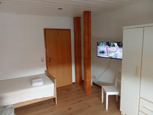 a small room with a bed and a tv on a wall at Zimmervermietung Weitblick in Burgdorf