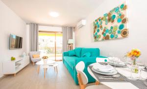a living room with a blue couch and a table at Ona Aquamarina in La Pineda