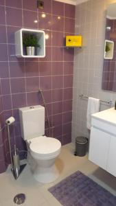 ColaresにあるApple Beach Apartmentの紫色のタイル張りの壁、トイレ付きのバスルーム