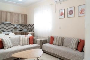 een woonkamer met twee banken en een keuken bij VILLA 24 Sarandë in Sarandë