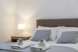 twee handdoeken met planten erop op een bed bij VILLA 24 Sarandë in Sarandë