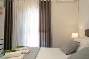 een slaapkamer met een bed en een raam bij VILLA 24 Sarandë in Sarandë