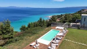 a villa with a swimming pool and a view of the ocean at Blue Dream Afytos in Afitos