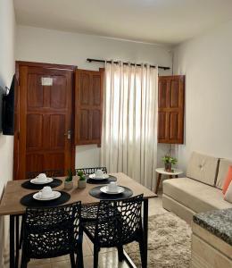 Una sala de estar con una mesa y sillas y un sofá. en Recanto Canuto, en Diamantina