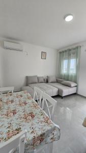 a white living room with a table and a couch at ValMar in Bar, Susanj