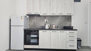 a kitchen with white cabinets and a white refrigerator at ValMar in Šušanj +18 photos