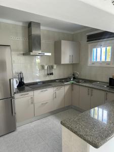 a kitchen with white cabinets and a stainless steel refrigerator at Paraíso Marino in Tías