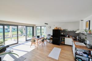 a kitchen and living room with a table and chairs at Mihelyünk Apartman in Fonyód