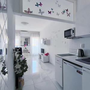 een witte keuken met vlinders aan de muur bij Cute studio-great location in Zadar