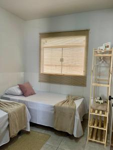 1 dormitorio con cama, escalera y ventana en Recanto Canuto, en Diamantina