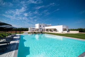 a swimming pool in front of a villa at Il Casale nel Parco in Ostuni