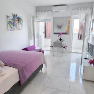 een witte slaapkamer met een paars bed en een bureau bij Cute studio-great location in Zadar