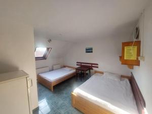 a small room with two beds and a desk at Hangya panzió in Tîrgu Secuiesc +28 photos